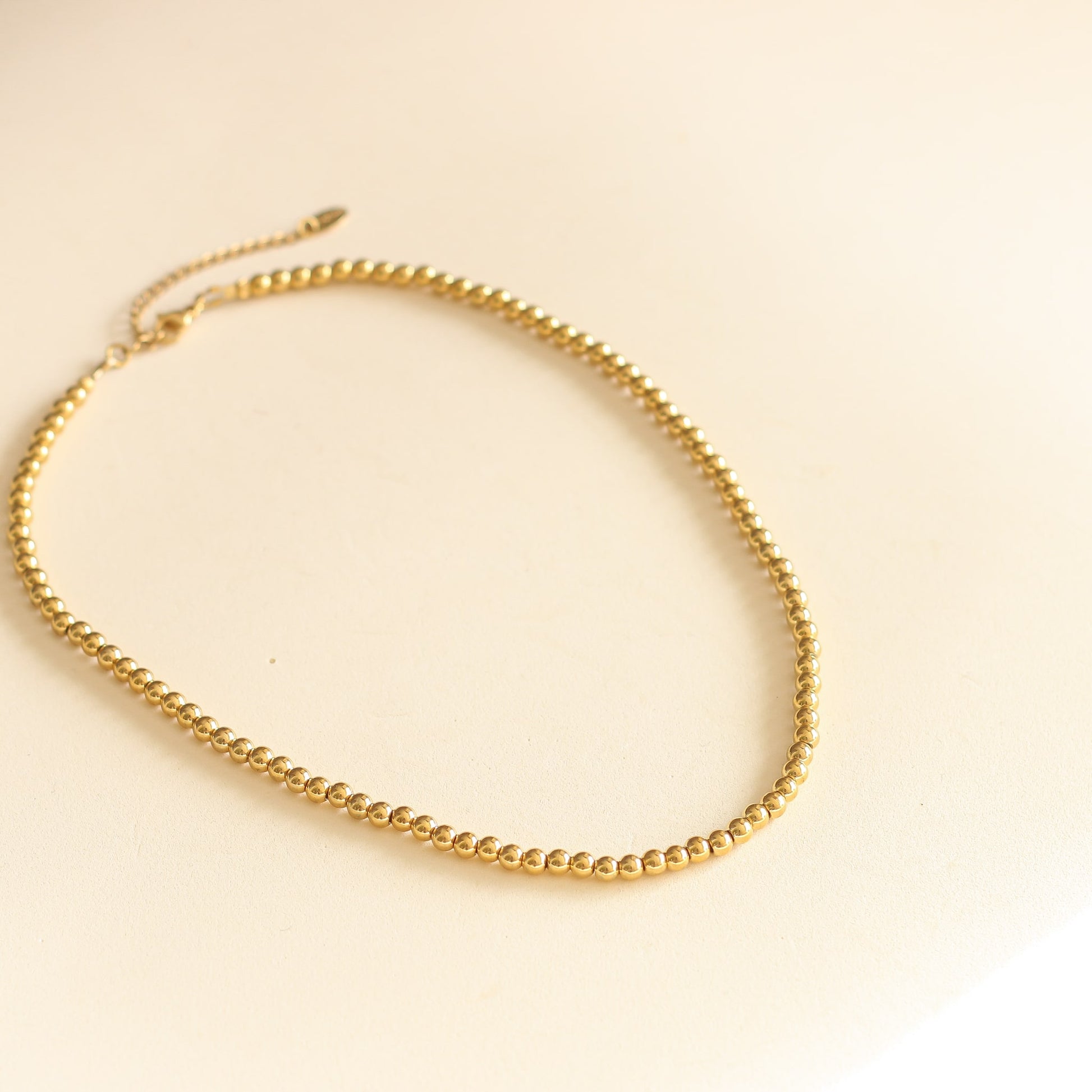 le cadeau simple collier à boules dorées