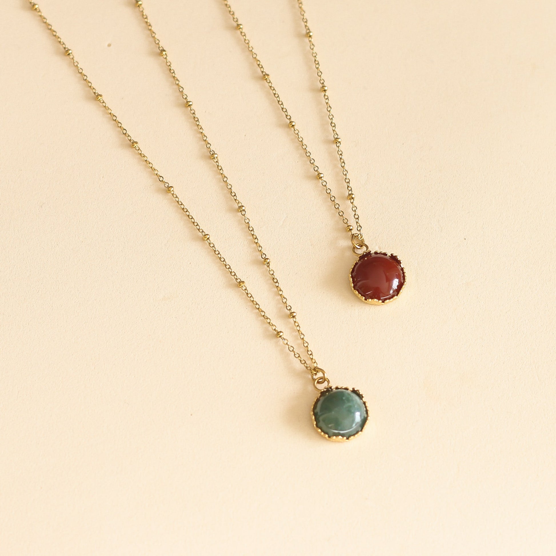 collier avec un pendentif doré et sa pierre de Cornaline sur une chaine à boules dorée 