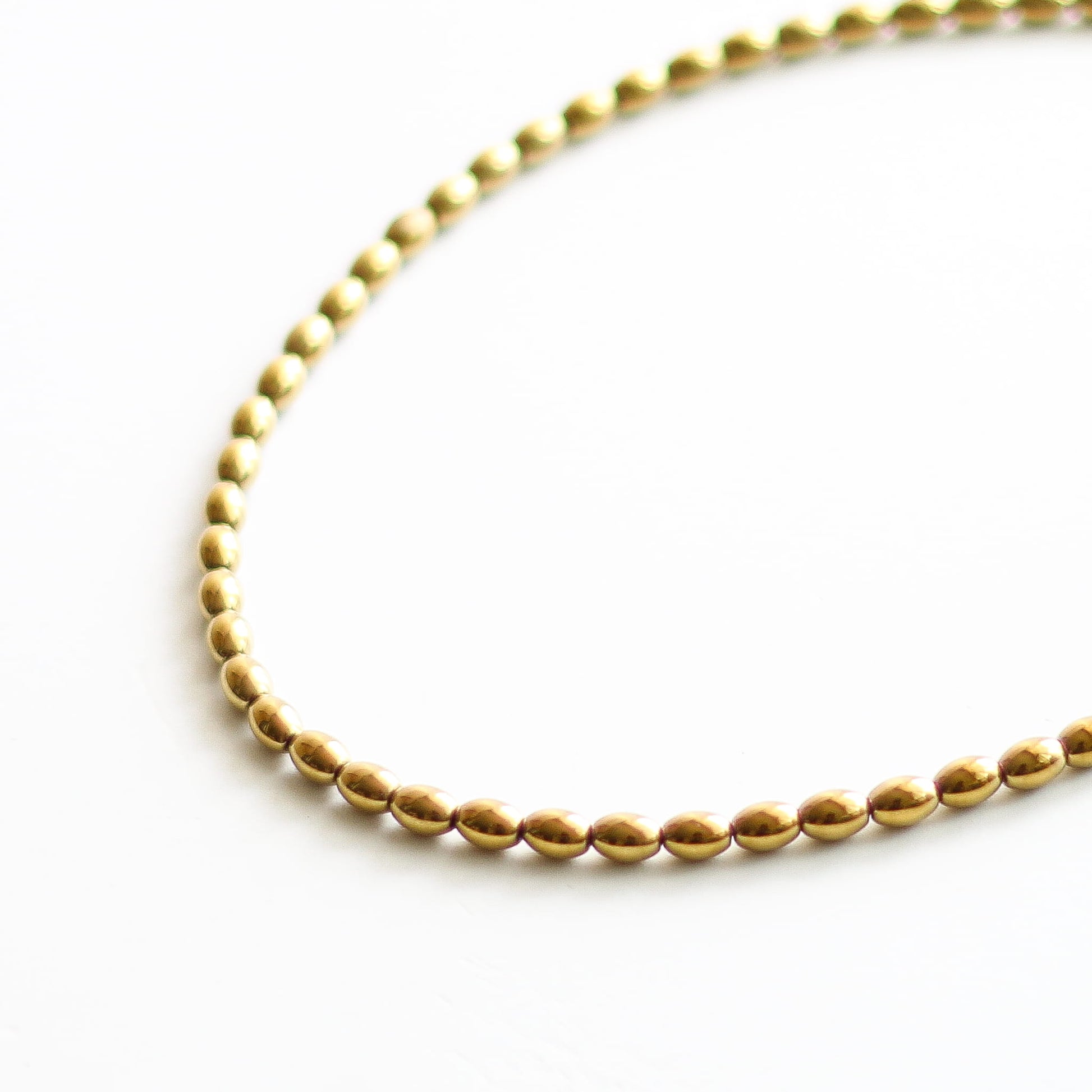 Collier en hématite dorée, acier inoxydable doré.
